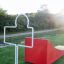 White metal training figure and red wave board on green outdoor grass field, Aim Practice I.