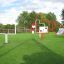 Outdoor setup of Aim Practice II playground equipment with red and white frames on green grass.