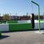 Outdoor green and white sports facility with Punching bag hanging from a metal frame.