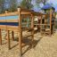 Romping Center single slide wooden play structure with climbing elements in a park.