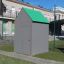 Playground shelter with green roof and gray walls.