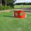 Goal - red soccer training wall with a circular hole on a green field