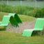 Green Lounge chair set designed for outdoor playground seating on grass.
