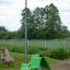 Green Lounge chair for playground seating on grass near lamp post