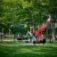 Twister castle with slide on a playground with children playing and parents watching.