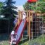 Children playing on Twister castle with slide in a park.