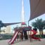 Twister castle with slide playground equipment in an urban park setting with Burj Khalifa in the bac