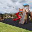 Twister castle with slide in a playground, featuring a tower, a red spiral slide, and a climbing wal