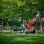 Twister castle with slide on a playground with children playing and parents watching.