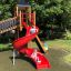 Children playing on Twister castle with slide in a park.