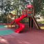 Twister castle with slide in a colorful playground surrounded by trees