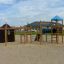 Motor Function Center wooden playhouse with climbing ropes, ladders, and a slide on a sandy playgrou