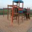 Wooden Motor Function Center playhouse for children with climbing nets and slides.