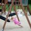 Two girls playing on Double Swing (BNS 90cm) at the playground.