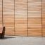 Modern wooden Sofa Wave in front of a wooden wall.