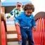 Children playing on Square Play castle with slide.