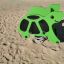 Green Turtle rocking playground spring rider on sandy surface.