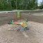 Quark rocking playground equipment with green handles on a sandy play area.