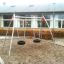 Double Swing with tire seats in a playground area.