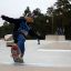 A young skateboarder performing a trick on the Corner skate park module.