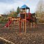 Tritowers castle with slide in a playground setting.