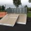 Quarter 2 - skateboard ramp with wooden surface in a park.