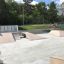 Quarter 2 skate park ramp set in an outdoor area with greenery in the background.