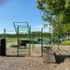 Outdoor fitness obstacle course with green bars and wooden ramp from New Age Fit.