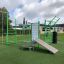 Outdoor fitness equipment New Age Fit involving various workout stations on a grassy field.