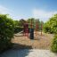 Outdoor fitness playground equipment 'New Age Fit' set in a green park.