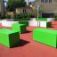 Green benches and play structures of Multiarena in a playground.