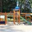 Space Station castle with slide in a playground surrounded by trees.