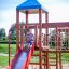 Child sliding down the red slide of the Space Station castle with slide playground equipment.