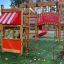Wooden playground structure with red slide and climbing ladder.