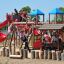 Children playing on the Space Station castle with slide in a playground.