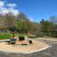 Villa Maxi sandbox with a playhouse in a playground surrounded by nature.