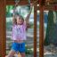 Girl playing on chimpanzee wooden playhouse.
