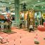 Chimpanzee wooden playhouse in an indoor play area with children and parents around.