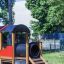 Playground Train structure made of wood and plastic with a slide and tunnel.