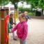 A child playing with the Clock playground equipment.