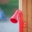 Red Megaphone playground equipment attached to wooden frame.