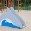 Dolphin Slide playground slide in the shape of a dolphin on a sandy playground.