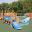 Playground equipment Small Ship with Dolphin on green outdoor surface.