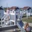 Children playing on the Small Ship with Dolphin playground structure.