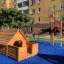 Wooden playhouse and mast climbing net with red flag on playground