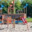 Mast climbing net on a playground with slides and wooden structures.