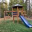 Playground structure Six Angle with Suspension Bridge single slide in a park setting.