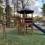 Six Angle with Suspension Bridge single slide playground structure in a park setting