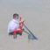 Child playing on red Excavator playground equipment digging sand.