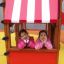 Two girls in a Logo Tower with Firepole playhouse with slide.